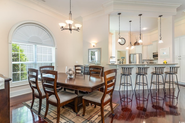 dining space featuring dark hardwood / wood-style flooring, a notable chandelier, and ornamental molding