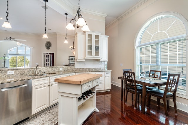 kitchen featuring white cabinetry, a center island, dishwasher, and sink