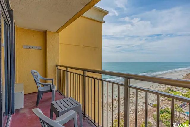 balcony featuring a beach view and a water view