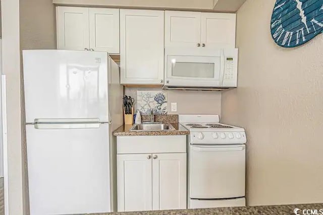 kitchen with sink, white appliances, and white cabinets