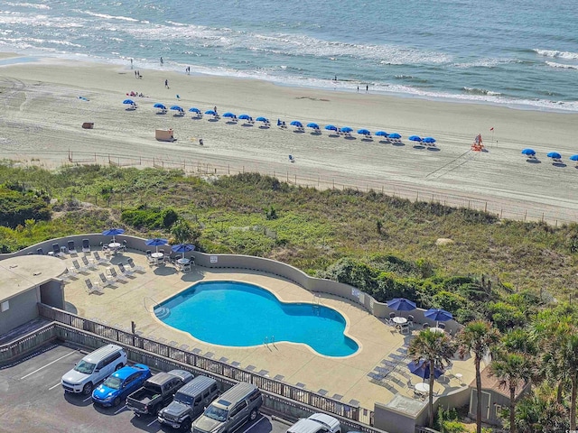 view of pool featuring a water view and a view of the beach