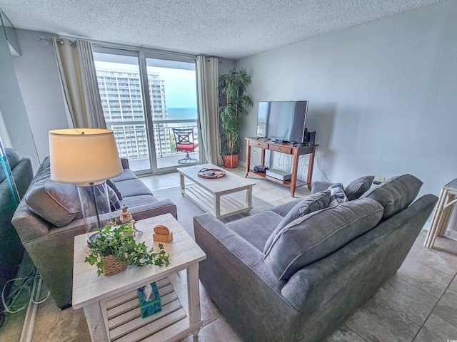 living room with a textured ceiling and a wall of windows