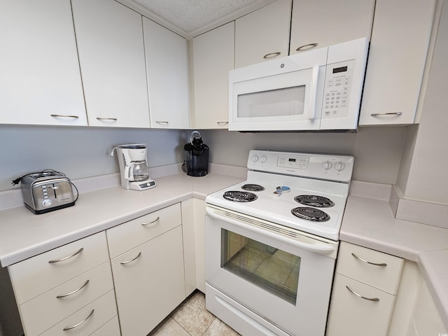 kitchen featuring a textured ceiling, light tile patterned floors, white appliances, and white cabinetry