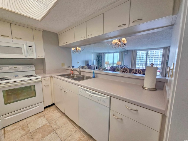 kitchen with white cabinets, white appliances, a textured ceiling, sink, and a notable chandelier