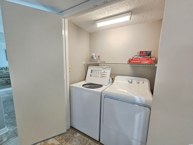 laundry area featuring a textured ceiling and washing machine and dryer