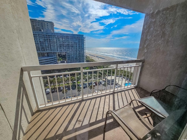 balcony featuring a view of the beach and a water view