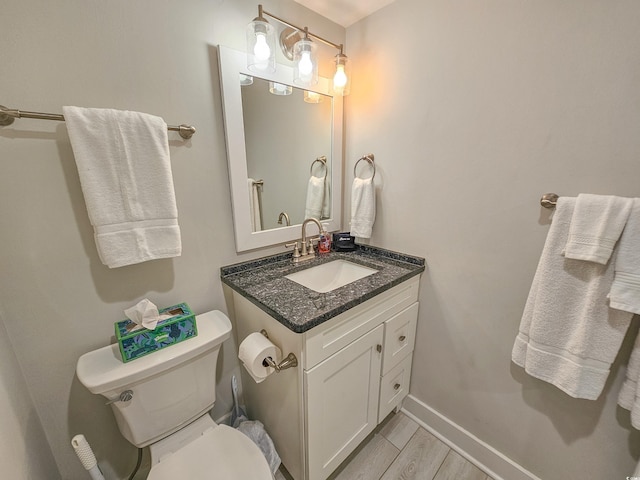 bathroom featuring vanity, toilet, and hardwood / wood-style flooring