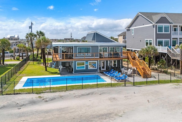 back of house featuring a swimming pool side deck and a lawn