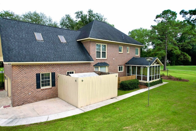 back of property featuring a lawn and a sunroom