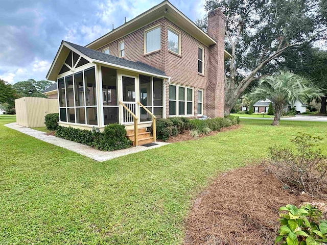 rear view of house with a sunroom and a yard