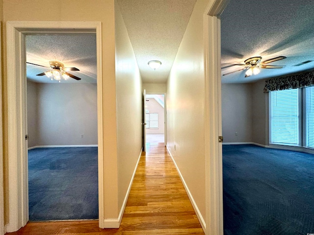 corridor featuring carpet flooring and a textured ceiling