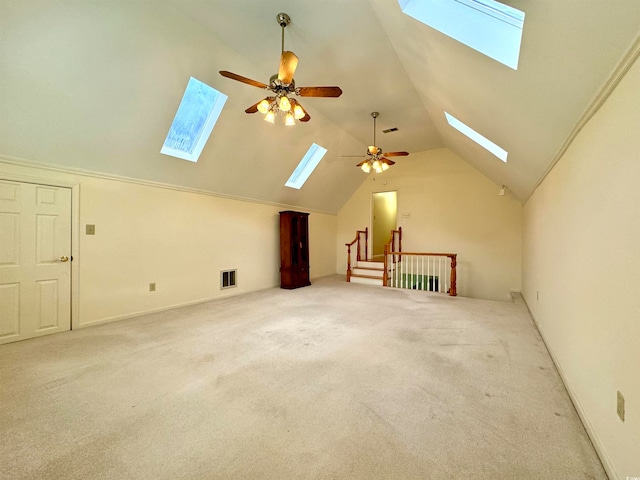 additional living space with light carpet, lofted ceiling with skylight, and ceiling fan