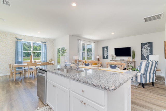 kitchen featuring a center island with sink, white cabinetry, a healthy amount of sunlight, and sink