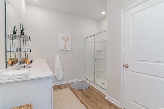 bathroom with vanity, a shower with shower door, and hardwood / wood-style flooring