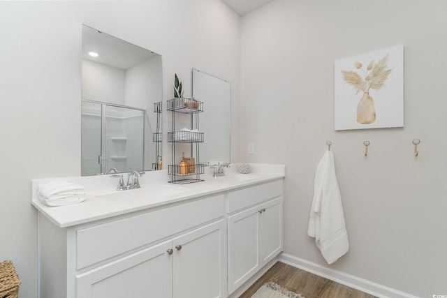 bathroom featuring hardwood / wood-style flooring, vanity, and a shower with shower door