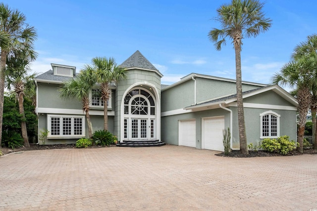 8000 Beach Dr, Myrtle Beach, SC 29572 - view of front of home with a garage, stucco siding, decorative driveway, and french doors