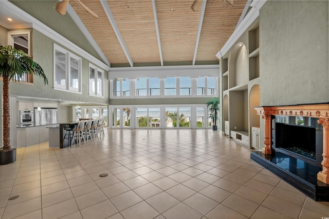 unfurnished living room featuring tile patterned floors, wood ceiling, high vaulted ceiling, beamed ceiling, and a premium fireplace