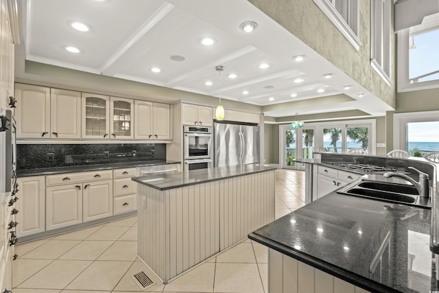 kitchen featuring pendant lighting, sink, light tile patterned floors, appliances with stainless steel finishes, and a center island