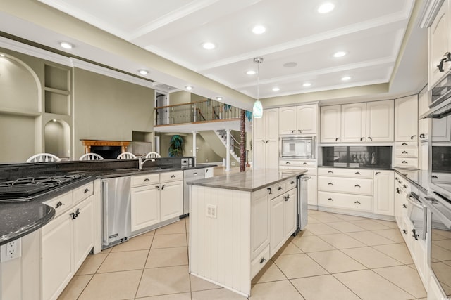 kitchen featuring light tile patterned floors, white cabinetry, a center island, ornamental molding, and built in microwave