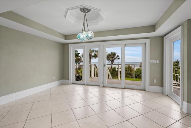 8000 Beach Dr, Myrtle Beach, SC 29572 - unfurnished room with a raised ceiling, baseboards, light tile patterned flooring, and a notable chandelier