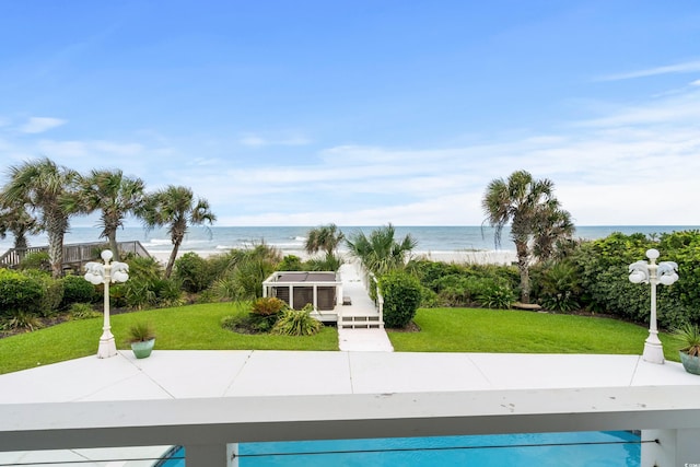 view of pool with a water view and a yard