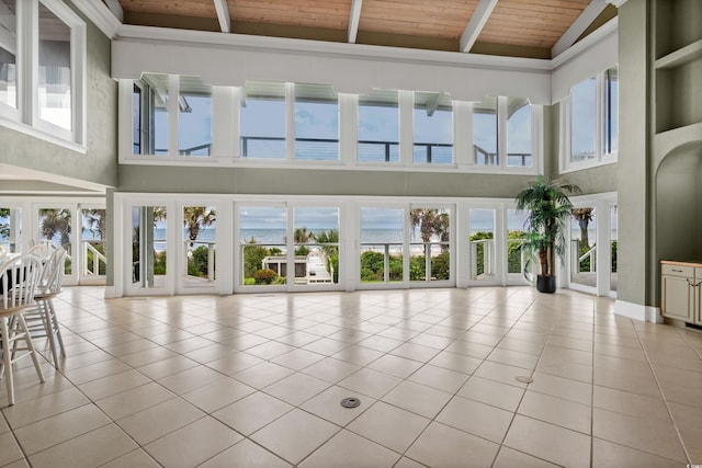 8000 Beach Dr, Myrtle Beach, SC 29572 - unfurnished living room featuring wooden ceiling, light tile patterned floors, high vaulted ceiling, and beamed ceiling