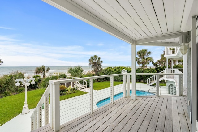 deck with a yard, a beach view, and a water view