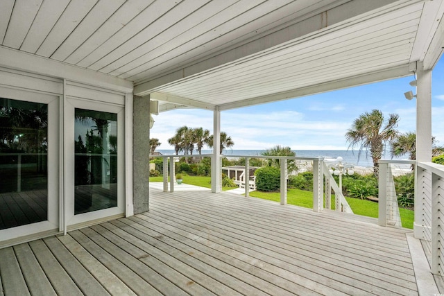 wooden terrace featuring a water view and a view of the beach