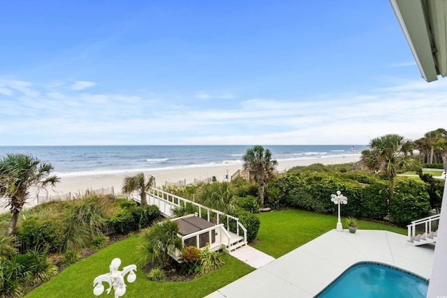 view of swimming pool featuring a view of the beach, a patio area, and a water view