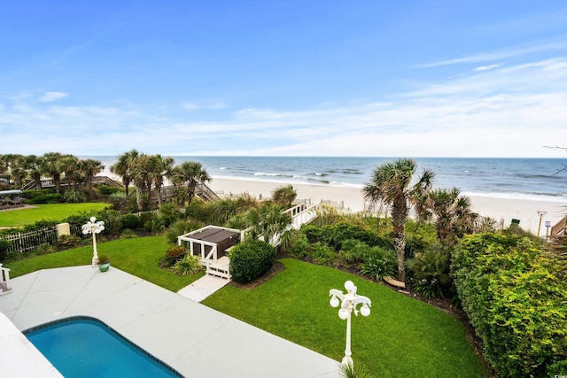 exterior space with a patio area, an outdoor structure, a beach view, and a water view