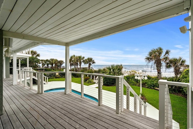 deck featuring a water view and a beach view