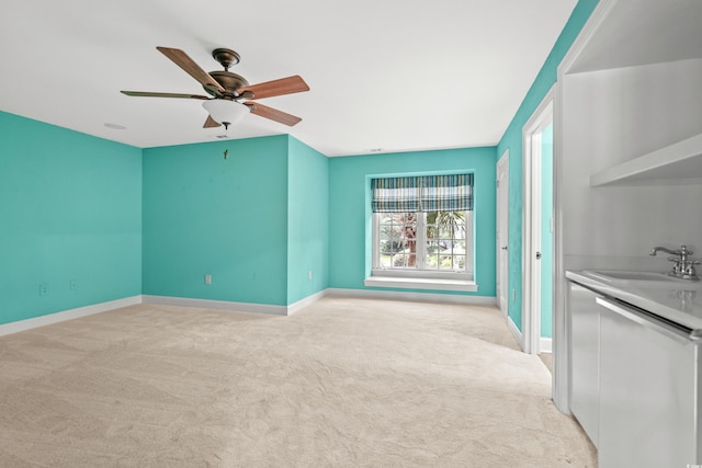 interior space featuring light carpet, sink, and ceiling fan