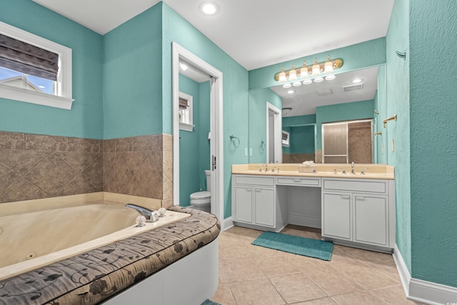 bathroom with tile patterned flooring, vanity, a washtub, and toilet