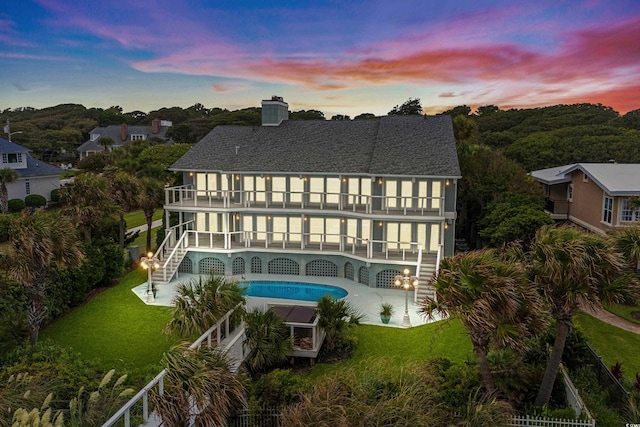 8000 Beach Dr, Myrtle Beach, SC 29572 - rear view of house with a patio, an outdoor pool, a lawn, and a balcony