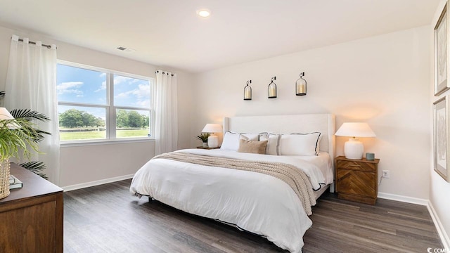 bedroom with dark hardwood / wood-style floors