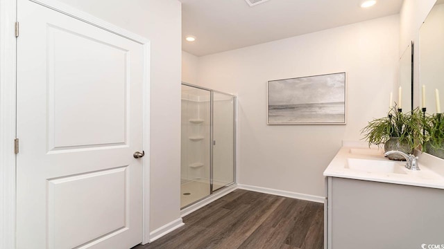 bathroom featuring vanity, an enclosed shower, and wood-type flooring