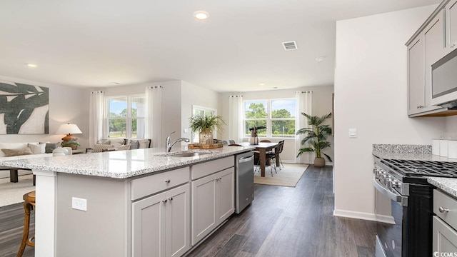 kitchen featuring a healthy amount of sunlight, a center island with sink, stainless steel appliances, and sink
