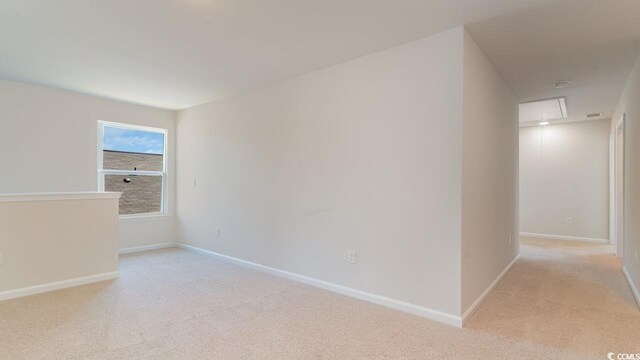 spare room featuring light carpet