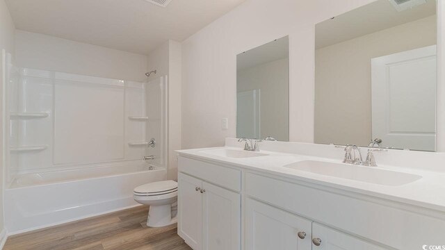 full bathroom with toilet, vanity, bathtub / shower combination, and hardwood / wood-style flooring