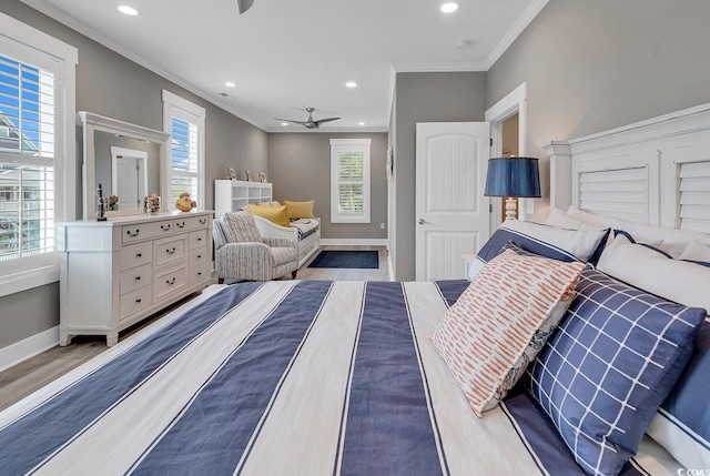 bedroom featuring multiple windows, hardwood / wood-style flooring, and ornamental molding