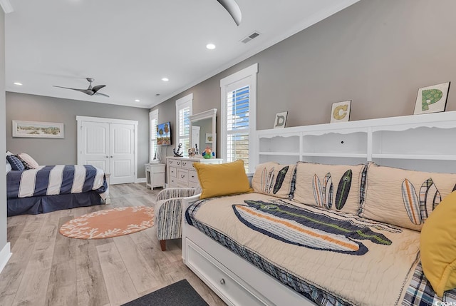 bedroom with light hardwood / wood-style floors, a closet, and ceiling fan