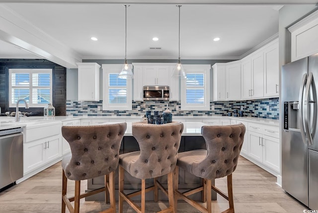 kitchen with decorative backsplash, light wood-type flooring, and stainless steel appliances