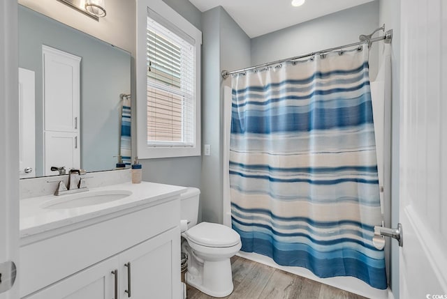 bathroom featuring vanity, toilet, wood-type flooring, and a healthy amount of sunlight