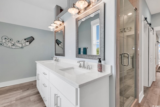 bathroom featuring walk in shower, double sink vanity, and hardwood / wood-style floors