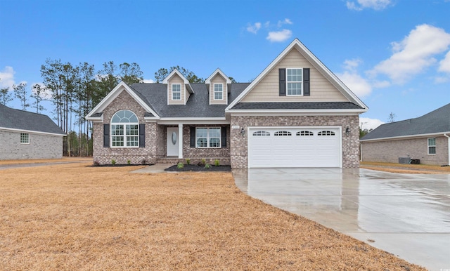 view of front of home featuring a front lawn, central AC, roof with shingles, a garage, and driveway