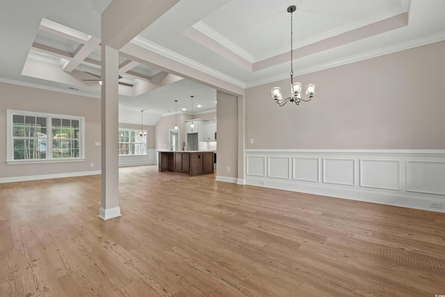 unfurnished dining area featuring light wood-type flooring, ornamental molding, coffered ceiling, a decorative wall, and a chandelier