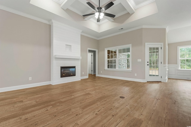 unfurnished living room featuring a large fireplace, ceiling fan, ornamental molding, and light wood finished floors