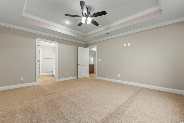 unfurnished bedroom with a tray ceiling, baseboards, and light colored carpet