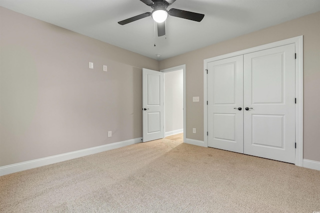 unfurnished bedroom featuring light carpet, a closet, baseboards, and a ceiling fan