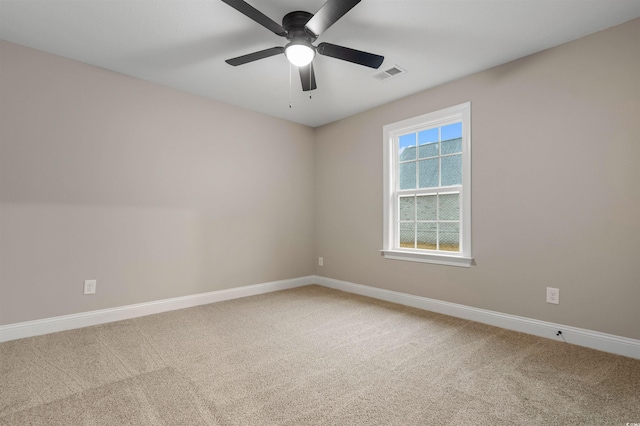 carpeted spare room featuring visible vents, ceiling fan, and baseboards